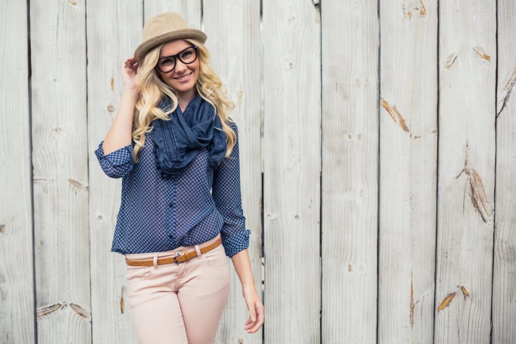 Smiling trendy model posing on wooden background